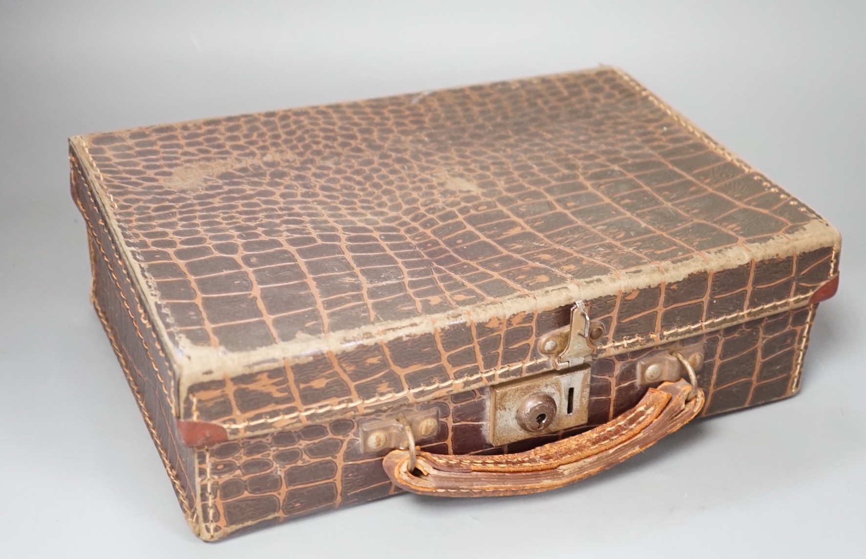 A moulded resin chess set in faux crocodile suitcase